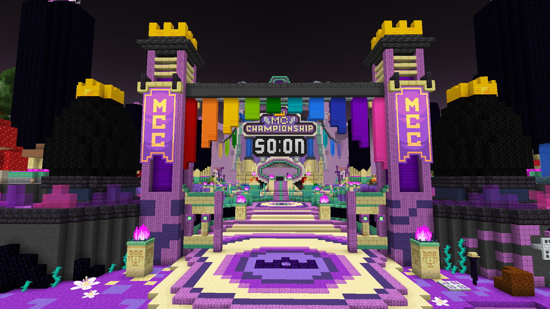 A colourful End dimension, with an Ender Man statue. Two obsidian towers with glowing End crystals and purple symbols stand tall in the background, in various biomes.